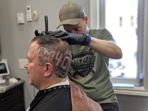 Handout/Chatham Daily News Greg Dennis, owner of Black Comb Barbershop in Blenheim, puts the finishing touches on a hair tattoo Chatham-Kent Mayor Darrin Canniff will be sporting this weekend, after an anonymous donor stepped up on Friday to donate $10,000 to the Children's Treatment Centre Foundation of Chatham-Kent.