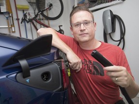 Free power. Daniel Bratt is shown June 13, 2019, with the charger to his Tesla Model 3 at his home in Amherstburg.  Bratt is offering up his charging station to the public via an online app called PlugShare.