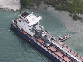 A tug boat works to free the bulk carrier ship Algoma Niagara that is shown on June 18, 2019 near the Windsor Salt mine along the Detroit River in Windsor.