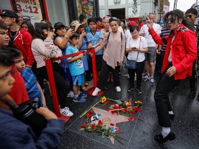 A Michael Jackson impersonator dances next to Michael Jackson's star on the Hollywood Walk of Fame 10 years after the death of the King of Pop in Los Angeles, on Tuesday, June 25, 2019.