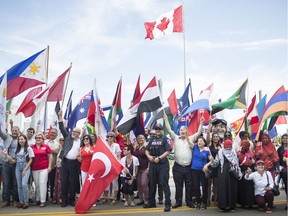 Newcomers, community partners, and the staff of the Multicultural Council of Windsor and Essex County gathered in front of the Great Canadian Flag to pose for a photo to celebrate National Multicultural Day, Thursday, June 27, 2019.