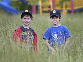 Liam Strong, 7, left, and Kanton Priscak, 6, are shown at  Tranby Park in Riverside where soggy conditions have made grass cutting impossible for city staff. The grass is about one metre high.