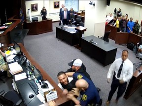 London Thomas is restrained after charging the jury box in this image from the video obtained by MLive.