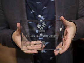 Vincent Georgie, executive director and chief programmer for the Windsor International Film Festival, holds up the award that the festival is now the largest volunteer run film festival in Canada on June 28, 2019.