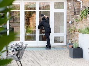 A burglar at the back door of a home. Illustration.