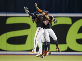 Anthony Santander #25, Stevie Wilkerson #12, and Keon Broxton #9 of the Baltimore Orioles celebrate defeating the Toronto Blue Jays following their MLB game at the Rogers Centre on July 5, 2019, in Toronto.