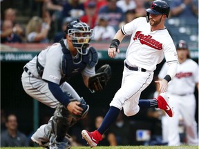 Tyler Naquin of the Cleveland Indians scores past Bobby Wilson of the Detroit Tigers on  a double by Francisco Lindor during the second inning at Progressive Field on July 16, 2019 in Cleveland, Ohio.