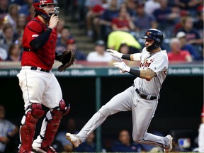 Nicholas Castellanos #9 of the Detroit Tigers scores past Roberto Perez #55 of the Cleveland Indians on a single by Jeimer Candelario #46 during the sixth inning at Progressive Field on July 17, 2019 in Cleveland, Ohio.