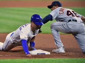 Whit Merrifield of the Kansas City Royals slides into third for a stolen base against third baseman Jeimer Candelario of the Detroit Tigers in the eighth inning at Kauffman Stadium on July 12, 2019 in Kansas City, Missouri.