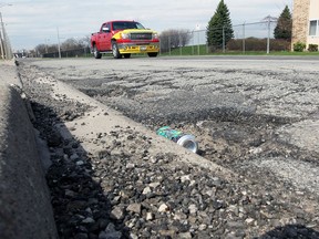 Potholes on Seminole Street near Central Avenue are seen as large piles of stone and old asphalt remain on the side of the road.