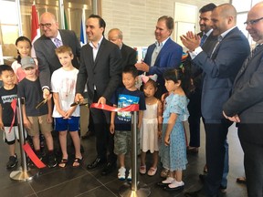 Children of Windsor who contributed artwork to the Why I Love Our City art display gather around as Mayor Drew Dilkens and Mayor Manolo Jimenez of Saltillo, Mexico, officially open the exhibit in the lobby of city hall.