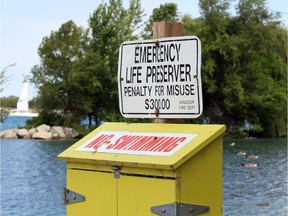A life preserver box posted with a NO SWIMMING notice on the Detroit River west of the Ambassador Bridge Monday.