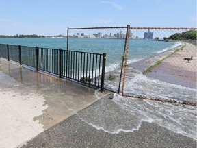 Waves from the wake of a passing motorboat crash over the pier located on the Windsor riverfront at the Ambassador Bridge Monday.