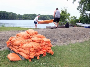 A skid of sandbags are ready for use at Shanfield Park Shores Park in East Riverside Tuesday. In photo, kayakers prepare to launch for a paddle to Peche Island.