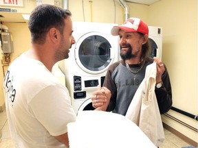 Pharmacist Frank Vella, left, of Medica Pharmacy is thanked by David Garvin, 55, at Windsor Essex Community Health Centre Wednesday. Vella donated $6000 to the centre which went toward the installation of a new washer and dryer for area homeless and those near homelessness.