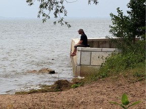 Ryan Alice of Essex peers out over the water of Lake Erie, while visiting Holiday Beach where his children were attending Natural Pathways Learning Centre.  Because of high lake levels and widespread erosion of the beach, Alice has only memories of what the beach once was.