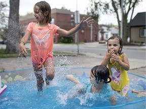 Sisters, from left, Cloie Joyal, 7, Nova Joyal, 5, and Emma Letourneau, cool down in their front yard pool on Langlois Avenue on Friday, as a heat wave engulfed Windsor and Essex County.