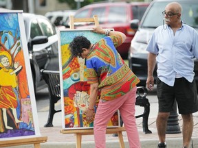 Windsor artist Rashmi Dadwal puts her paintings on display at the Walkerville Art Walk on Friday July 19, 2019 while her husband, Abhay Dadwal, looks on. The event will continue on Saturday from noon to 7 p.m. with artists, clothing merchants, and food vendors selling their wares along Wyandotte Street East in Walkerville.