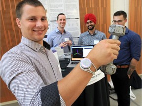 University of Windsor engineering student Jeff Bilek, front, demonstrates a wearable device which monitors your personal workout at Capstone Design Demo Day at the University of Windsor's Faculty of Engineering on July 26, 2019. In the rear are fellow team members Aaron Marson, left, Larry Sandhu and Connon Holowachuk.