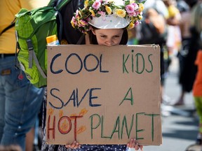 Eight-years-old Ida holds a poster reading "Cool kids save a hot planet" as she takes part in a Fridays For Future demonstration for climate protection in Juechen, western Germany, on June 22, 2019, during a weekend of massive protests in a growing "climate civil disobedience" movement.