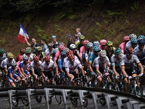 The pack rides in a curve during the sixth stage of the 106th edition of the Tour de France cycling race between Mulhouse and La Planche des Belles Filles on July 11, 2019.