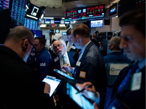 In this file photo taken on May 23, 2019 traders work after the closing bell at the New York Stock Exchange (NYSE) on Wall Street in New York City.