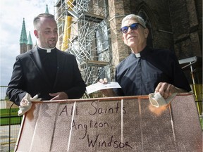 Fr. Maurice Restivo of Assumption Parish receives a cheque for $250 on Monday from Rev. Robert Clifford, left, of All Saints' Anglican Church, to go towards Assumption Church restoration efforts.