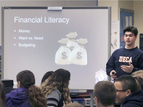 Financial literacy with be taught in all Ontario high schools in the fall. In this Dec. 14, 2018, file photo, Sandwich Secondary School student Christopher Lanno speaks to elementary students at LaSalle Public School as part of a student-led initiative aimed at fostering future financial success.