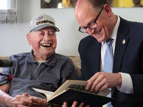 In this June 13, 2017 file photo, Ovil Lesperance, then 102, looks over his 1930 high school year book from Assumption with Windsor Mayor Drew Dilkens. The mayor visited Lesperance at his South Windsor home and was making an effort to visit as many centenarians as possible in conjunction with the city's 125 anniversary. He wants to do it again in 2019.