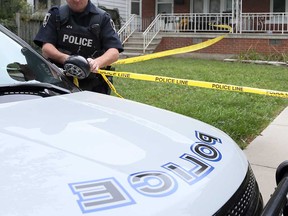 A Windsor police officer sets up crime scene tape during a homicide investigation in the 300 block of Hal Avenue in this September 2018 file photo.