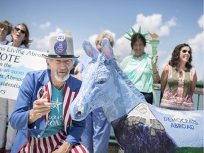 Ken Sherman, dressed as Uncle Sam, is pictured next to a donkey, a Democratic Party symbol, from the 2016 Democratic Party Convention in Philadelphia, as members of Democrats Abroad Canada meet at Dieppe Park before heading over the the first of two Democratic Debates at the Fox Theatre in Detroit, MI, Tuesday, July 30, 2019.