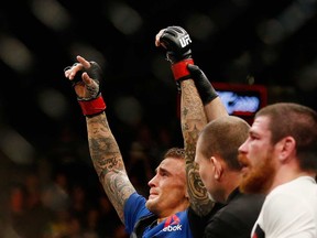 MMA fighter Dustin Poirier (left) raises his arms in victory after defeating opponent Jim Miller (right) at UFC 208 in New York City in February 2017.
