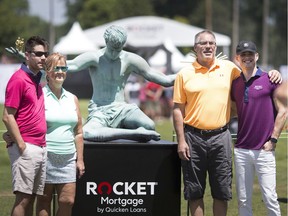 Golf fans pose for a photo in front of a replica of the Spirit of Detroit on the final day of the Rocket Mortgage Classic at the Detroit Golf Club, Sunday, June 30, 2019.