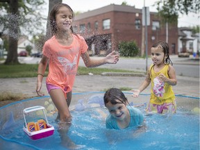 Sisters, from left, Cloie Joyal, 7, Nova Joyal, 5, and Emma Letourneau, cool down in their front yard pool on Langlois Ave., as a heat wave strikes Windsor and Essex County, Friday, July 19, 2019.