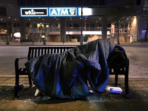 A homeless person sleeps on a bench in the 300 block of Ouellette Ave. on Monday, October 22, 2018 in downtown Windsor.