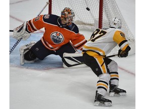 Pittsburgh Penguins Sidney Crosby (87) lifts the puck over Edmonton Oilers goalie Cam Talbot to score in overtime during NHL action at Rogers Place in Edmonton on Tuesday night.