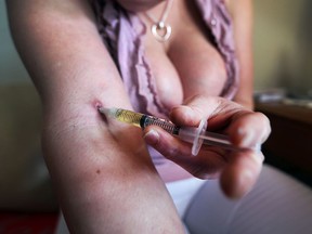 In this March 24, 2017, file photo, a prostitute injects herself with dilaudid at her Windsor residence.