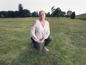 Somewhere here lies Evelyn Martin. Victoria Manor's director of resident services, Christine Dubruiel, is shown at the Victoria Memorial Gardens Cemetery on July 8, 2019, in an area where former residents are buried but have no grave markers.