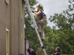 Suzi Mioc climbs a ladder during the second annual Women On Fire event, hosted by Tecumseh Fire, on Saturday, June 29, 2019.  The female-only recruitment training opportunity aims to get more females into emergency responder organizations.