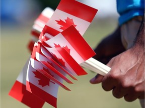 A volunteer holds souvenir flags in celebration of Canada Day.