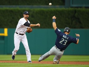 Jordy Merce of the Detroit Tigers turns a double play behind Austin Nola of the Seattle Mariners at Comerica Park on August 13, 2019 in Detroit, Michigan.