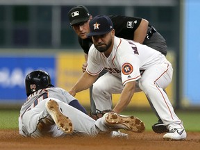 Jack Mayfield of the Houston Astros receives the throw from George Springer to tag out Travis Demeritte of the Detroit Tigers in the first inning at Minute Maid Park on August 19, 2019 in Houston, Texas.