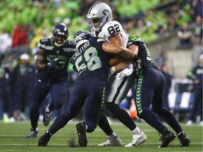 Luke Willson #82 of the Oakland Raiders is tackled by Austin Calitro #58 and Ben Burr-Kirven #55 of the Seattle Seahawks in the first quarter during their NFL preseason game at CenturyLink Field on August 29, 2019 in Seattle, Washington. Willson, a LaSalle, Ont., native, was released by the team.
