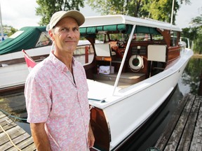 Rob Bondy stands on the dock in front of his 35-foot wooden cruiser, Pudgie, which was built in Essex 70 years ago. Bondy has owned and maintained the boat since 2007.