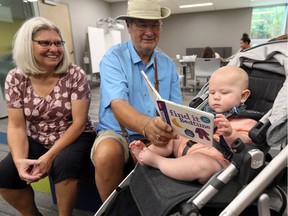 Grandparents Lillian and Kerry Stockford, left, assist grandson Norman Hendricks, 6 months old, during the grand opening of Leamington's downtown library.