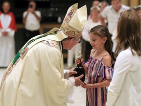 Bishop Ronald Fabbro, left, receives an offertory gift from Felicia Lattuca, during Sunday mass at 32nd Annual Madonna di Canneto Festival at Ciociaro Club of Windsor, Sunday.