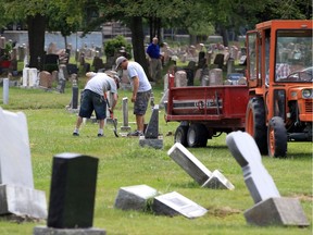 Windsor Memorial Gardens workers Ken Major, left, and Joe Mizzi do their best to keep up with repairing headstones at Windsor Grove Cemetery on Aug. 23, 2019.