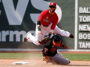 Dustin Pedroia of the Boston Red Sox turns a double play as Steve Pearce of the Baltimore Orioles slides into second base in the eighth inning during the first game of a doubleheader at Fenway Park on July 5, 2014 in Boston, Massachusetts.