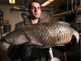 In this Jan. 16, 2014, file photo, Kevin Sprague, a conservation officer with the Ontario Ministry of Natural Resources, displays an Asian carp that was seized at the Windsor/Detroit border.