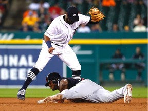 Cleveland Indians right fielder Yasiel Puig slides in safe at second base on a double ahead of the tag by Detroit Tigers shortstop Willi Castro in the fifth inning at Comerica Park.